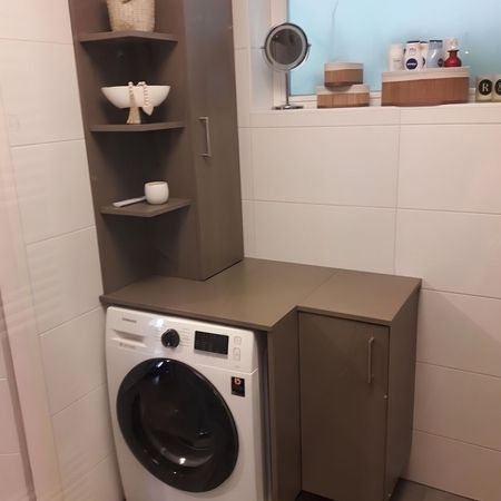 Eine Waschmaschine mit Möbeln aus Holz umbaut