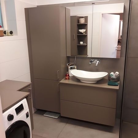 Ein Badezimmer mit grauen Möbeln