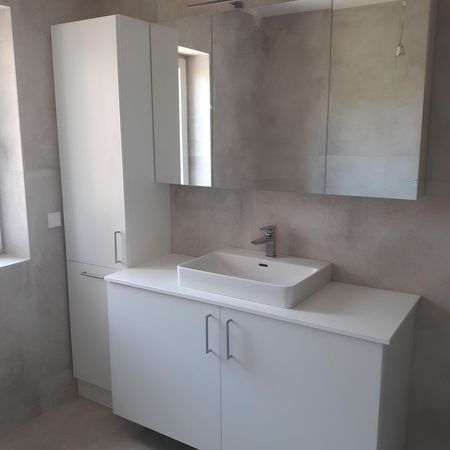 Ein Badezimmer mit weißen Möbeln